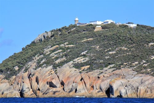 Rocky cliffs with Wilsons Promontory Lighthouse at the top.