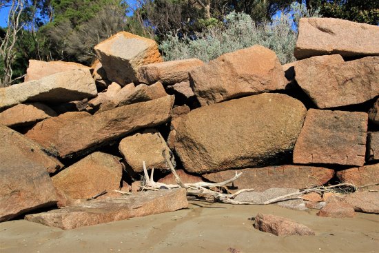 Blocks of pink granite stacked on the beach at Cape Woolamai, Phillip Island.
