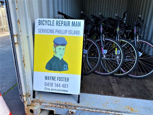 Advertising board for bike hire with bikes in background.