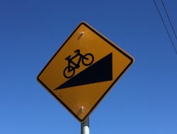 Road sign showing bike going uphill.