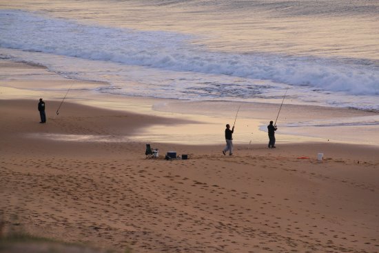Fishermen throwing in lines off the beach at dusk on Phillip Island