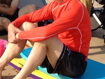 Swimmer wearing a rashie on the beach